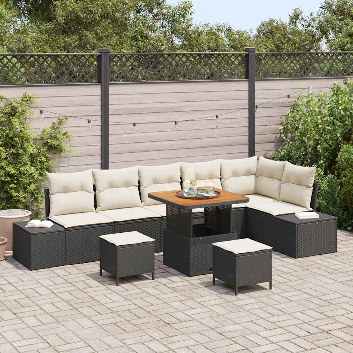 Outdoor-Ecksofa mit beigefarbenen Kissen, einem Holztisch und zwei kleinen Hockern auf einer Terrasse mit Zaun und Pflanzen.
