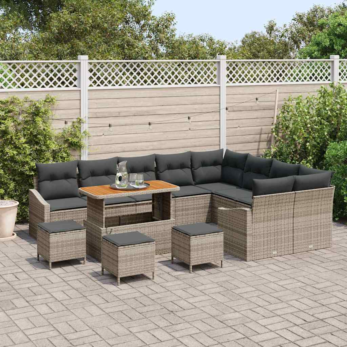 Outdoor-Sitzgruppe mit einem Sofa im Weidenstil, einem Tisch und Hockern auf einer Terrasse.