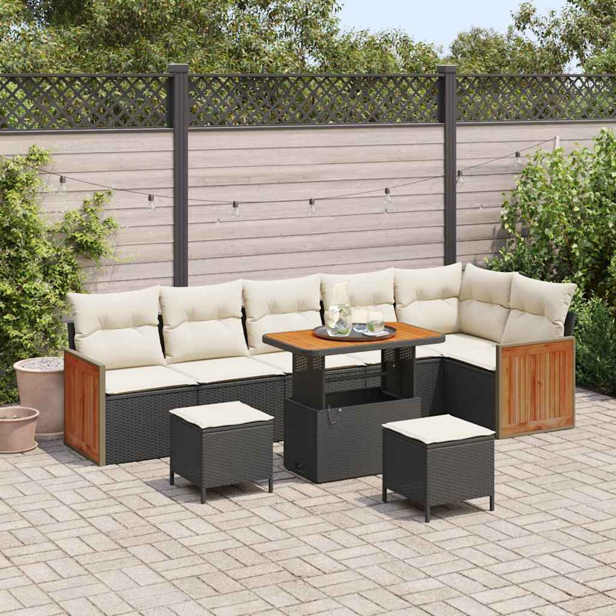 Terrassenset mit Ecksofa, Couchtisch und zwei Hockern. Cremefarbene Kissen, Holzakzente und Lichterketten. Ziegel-Patio.