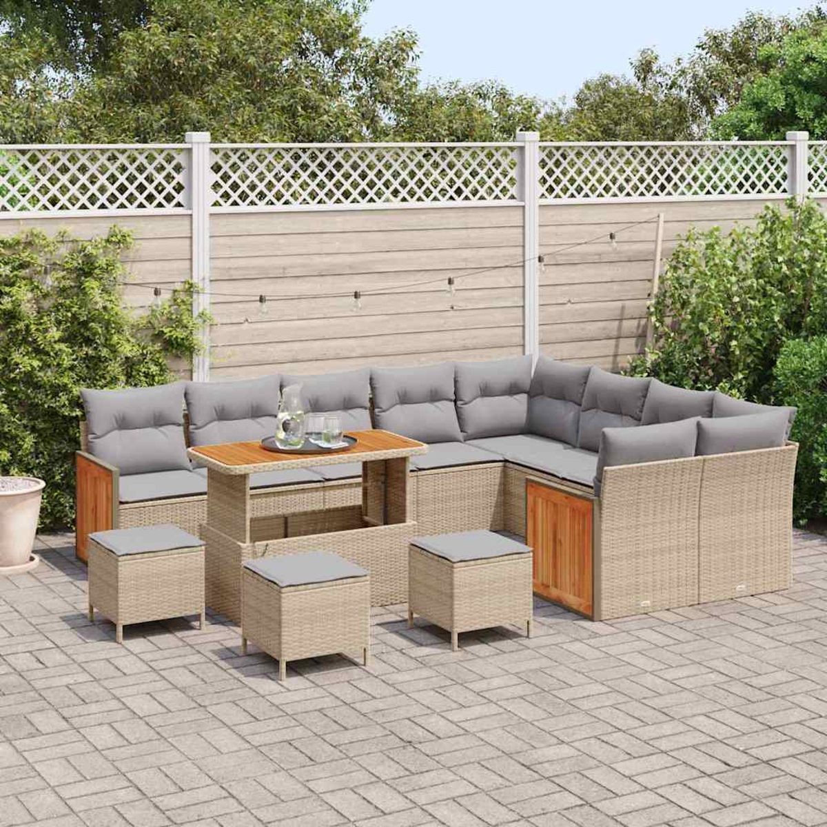 Outdoor-Ecksofa mit grauen Kissen, passenden Ottomanen und einem Holztisch. Im Hintergrund ein Holzzaun und Grün.