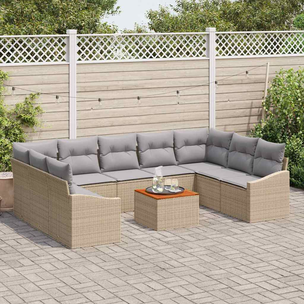Garten-Sitzgruppe mit grauen Kissen und einem kleinen Tisch. Im Hintergrund ein weißer Zaun und Grün.
