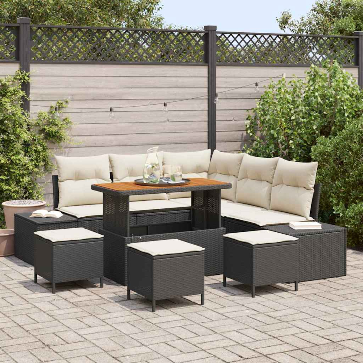 Dunkelgraues Outdoor-Terrassenmöbel-Set mit cremefarbenen Kissen, Tisch und Hockern, angeordnet auf einer Ziegelterrasse, mit einem Zaun im Hintergrund.
