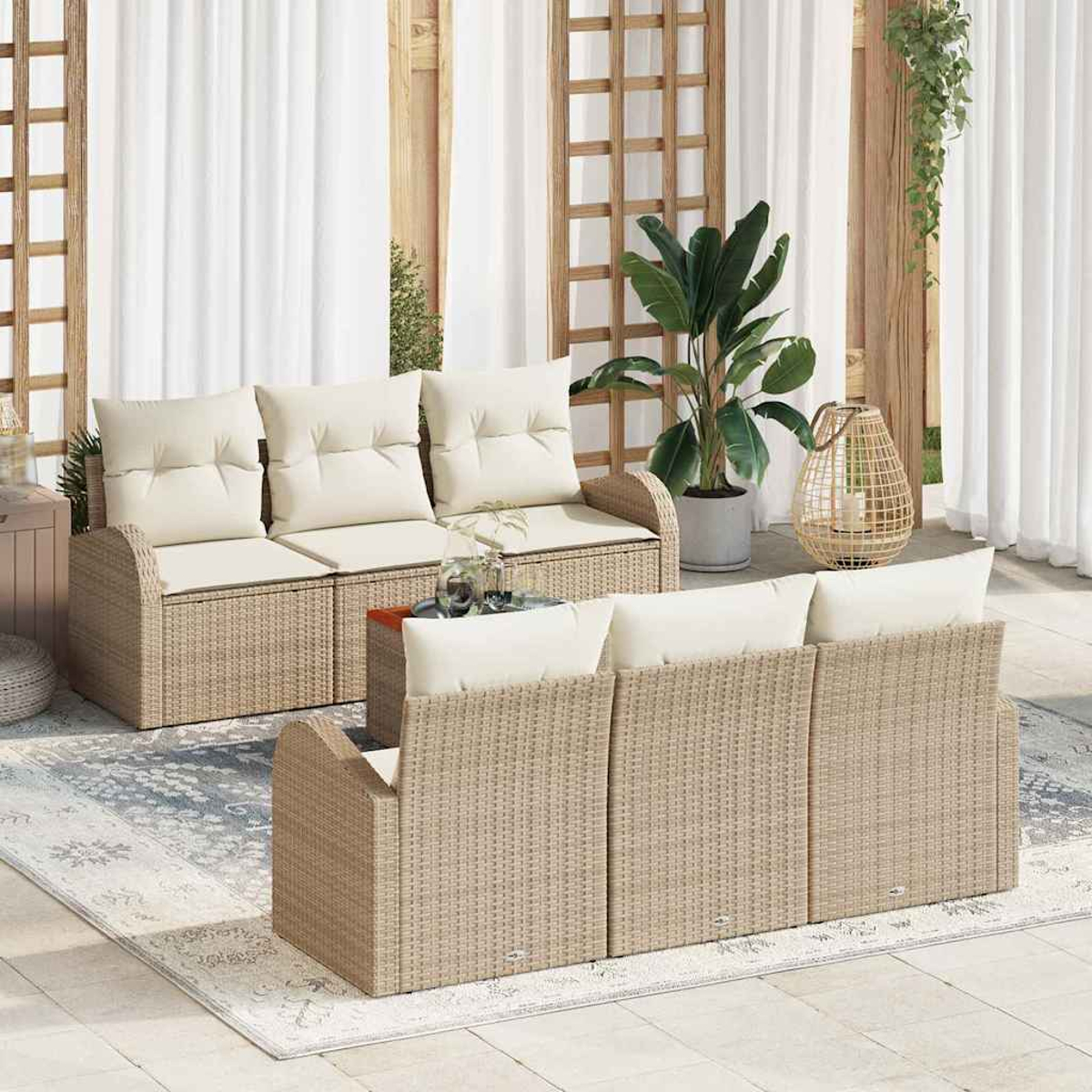 Outdoor-Szene mit Korbmöbeln. Beige Sofas mit weißen Kissen. Pflanzen, ein Teppich und Holzgitter schaffen eine entspannte Atmosphäre.