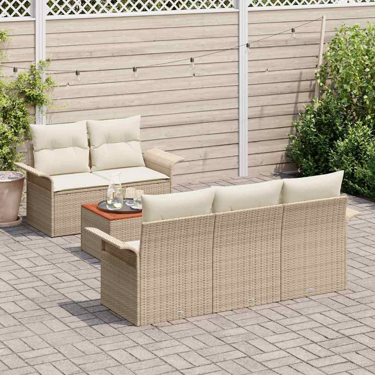 Garten-Terrassenset mit beigen Korbmöbeln, cremefarbenen Kissen, einem kleinen Tisch und einem Holzzaun im Hintergrund.