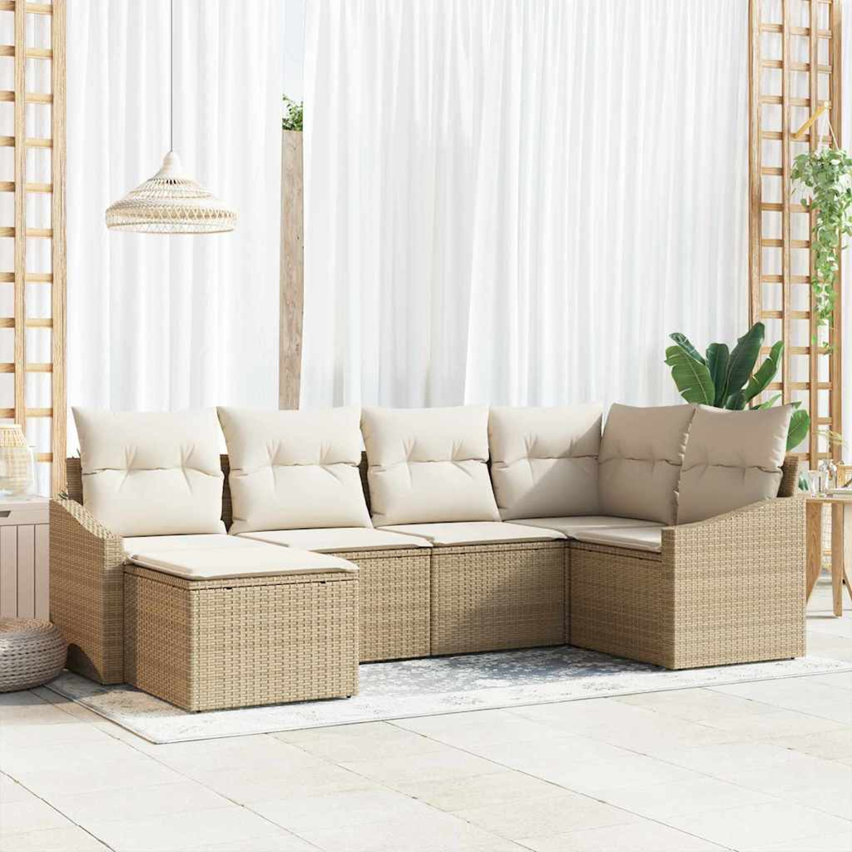 Ein beiges Korbsesselsofa mit cremefarbenen Kissen steht auf einer Terrasse. Weiße Vorhänge und eine gewebte Lampe hängen im Hintergrund.
