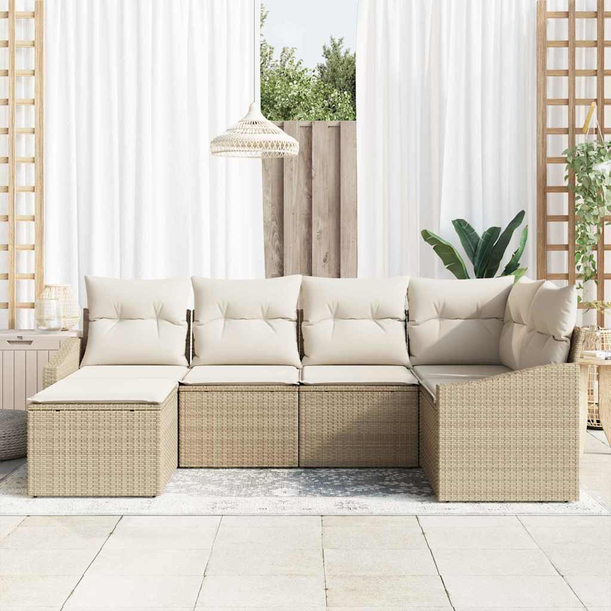 Beiges Outdoor-Korbsessel mit cremefarbenen Kissen. Weiße Vorhänge, ein Fenster mit Grün und eine gewebte Pendelleuchte sind sichtbar.