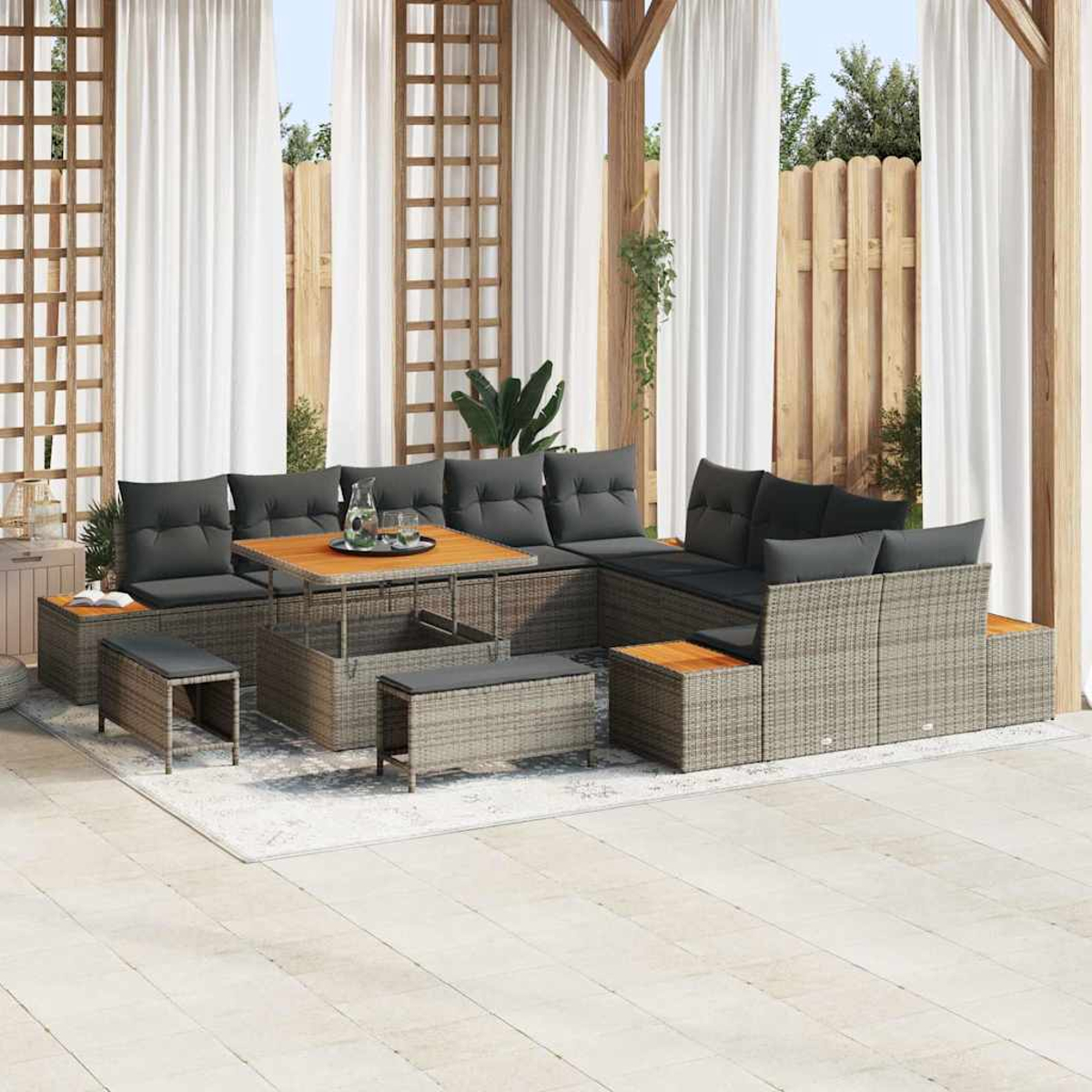Garten-Sitzgruppe mit grauen Kissen, Holztisch und Bänken. Weiße Vorhänge und Holzstruktur im Hintergrund. Terrasse.