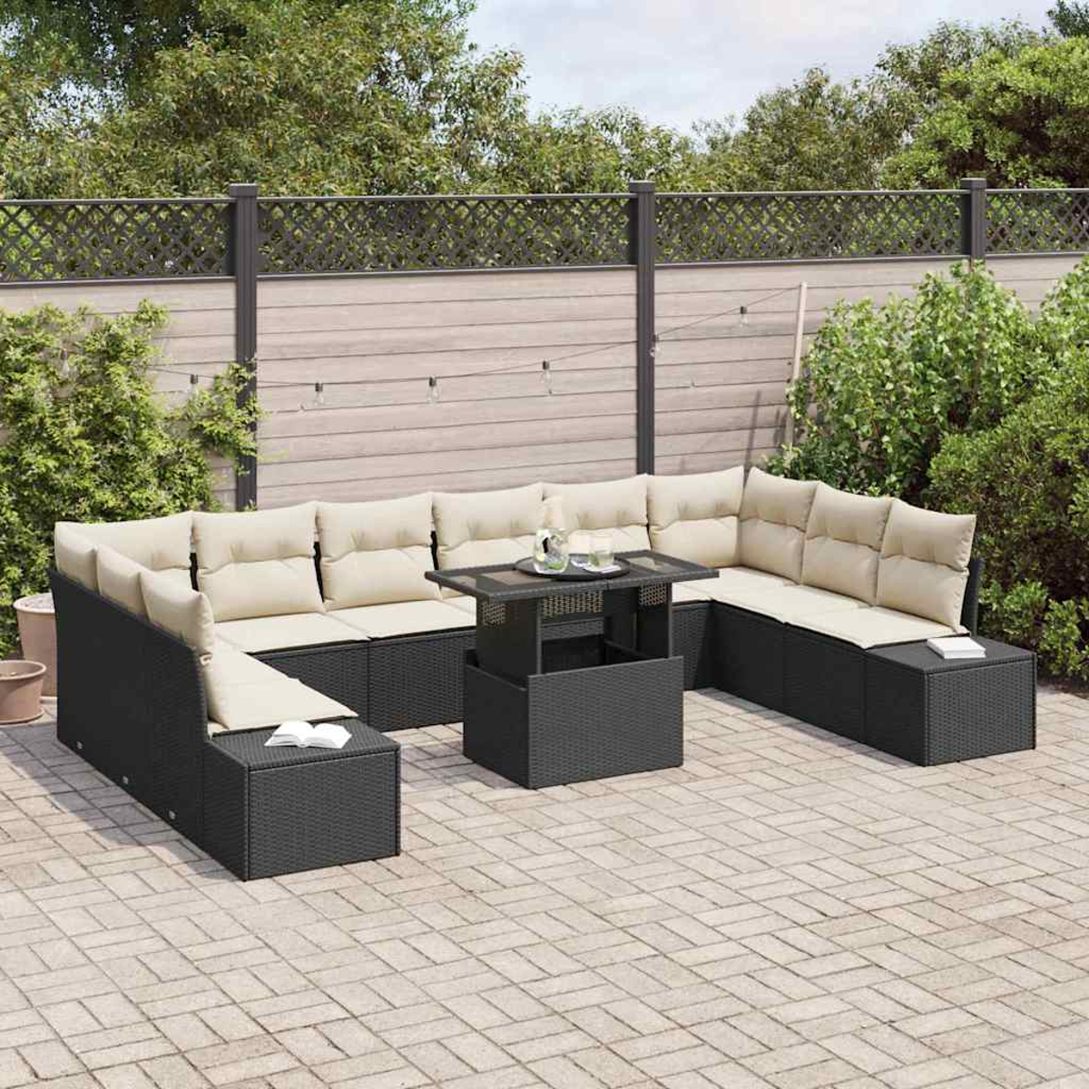 Schwarzes Ecksofa im Freien mit beigen Kissen und einem Tisch auf einer Ziegelterrasse. Hintergrund: Zaun und Pflanzen.