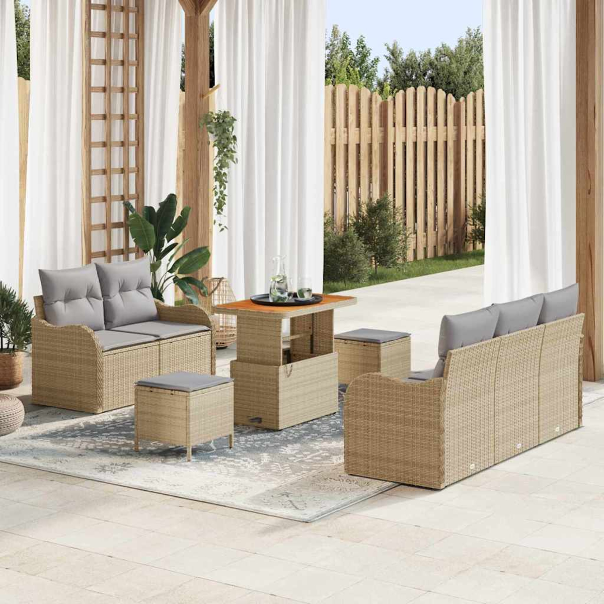 Gartenmöbel-Set aus Korbgeflecht mit grauen Kissen. Enthält Sofa, Zweisitzer, Tisch und Ottomanen auf einer Terrasse.