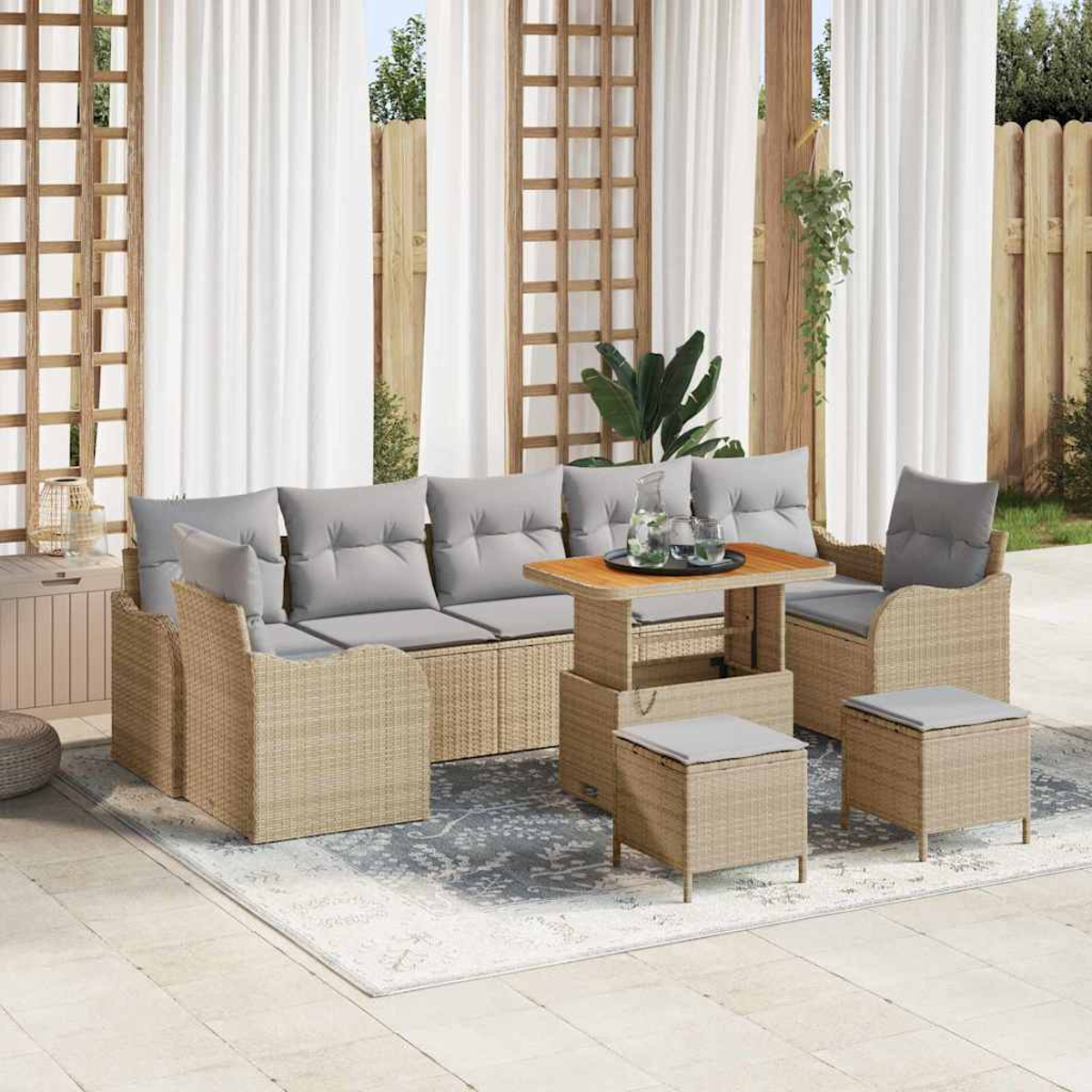 Gartenmöbel-Set aus Rattan mit grauen Kissen. Enthält ein Sofa, Stühle, einen Tisch und Ottomane auf einem gemusterten Teppich.