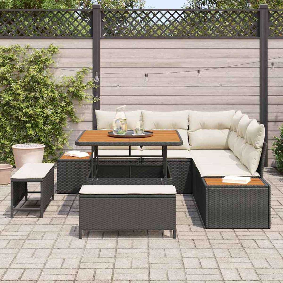 Gartenmöbel-Set mit Tisch, Sofa und Bank auf einer Terrasse. Wasserkrug und Gläser auf dem Tisch. Grüne Pflanzen und Holzzaun im Hintergrund.