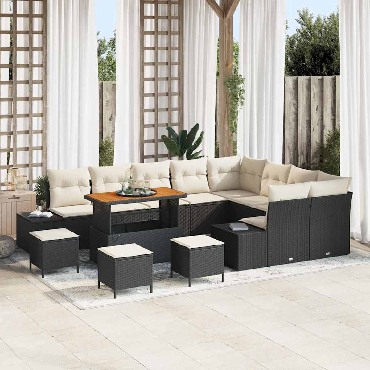Outdoor-Ecksofa mit beigen Kissen und einem Holztisch. Schwarze Korbmöbel mit weißen Vorhängen im Hintergrund.