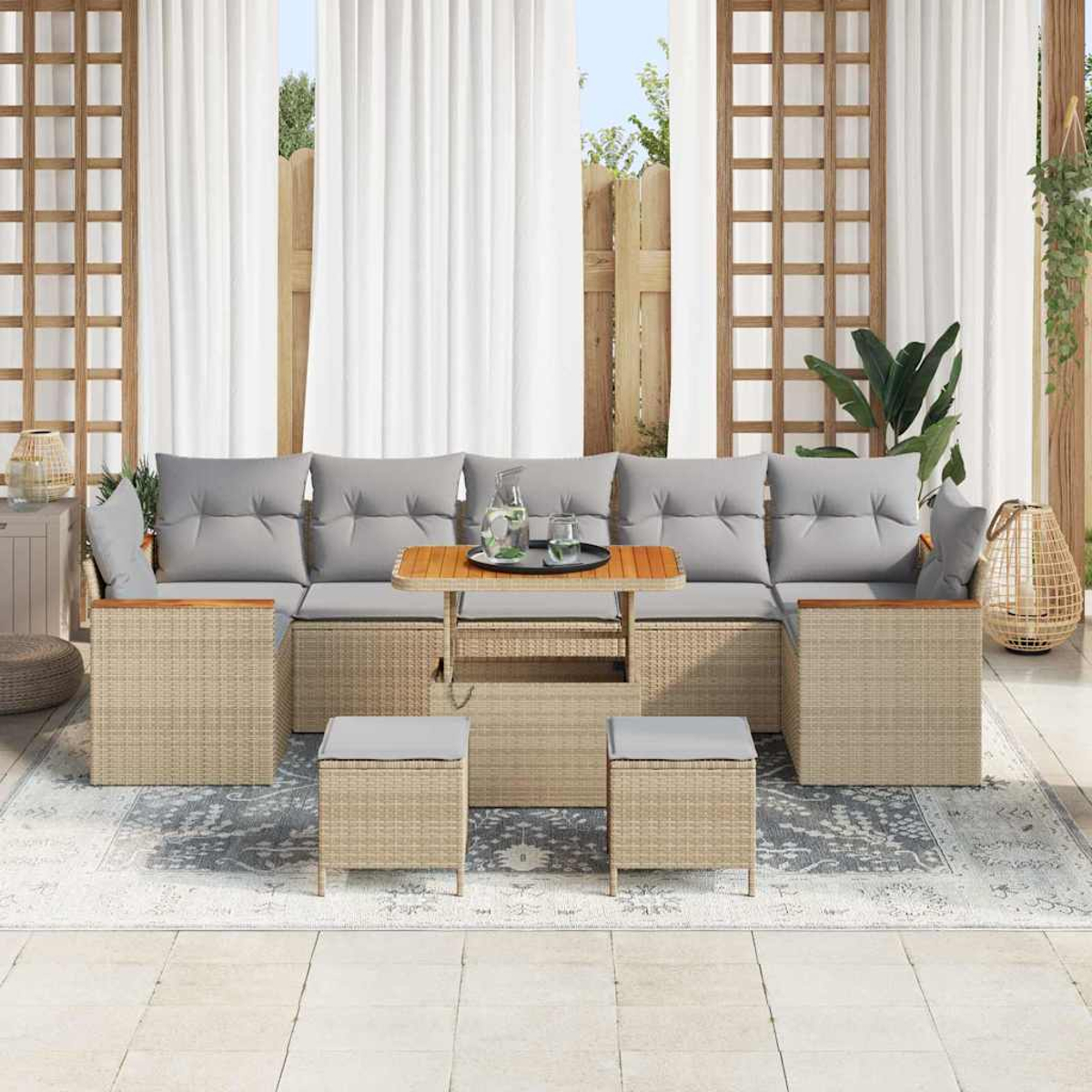 Outdoor-Terrassenset mit grauen Kissen. Enthält ein Sofa, Ottomane und einen Tisch. Vorhänge und ein Teppich vervollständigen die Szene.