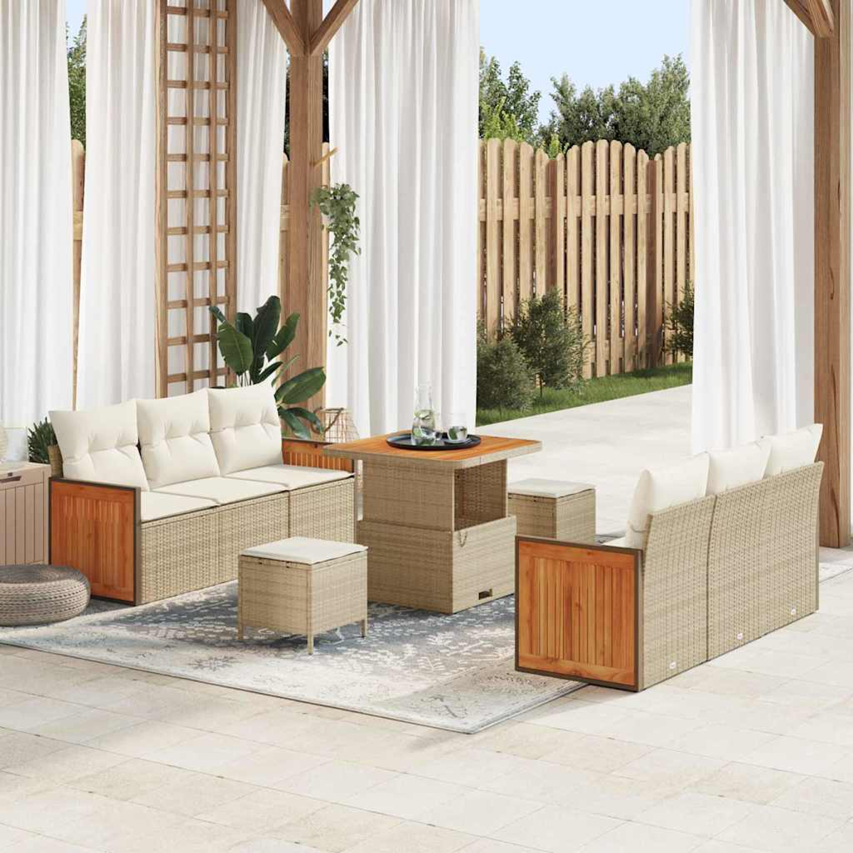Außenbereich mit Sofa, zwei Stühlen, Tisch und Teppich. Weiße Vorhänge und Holzzaun im Hintergrund.