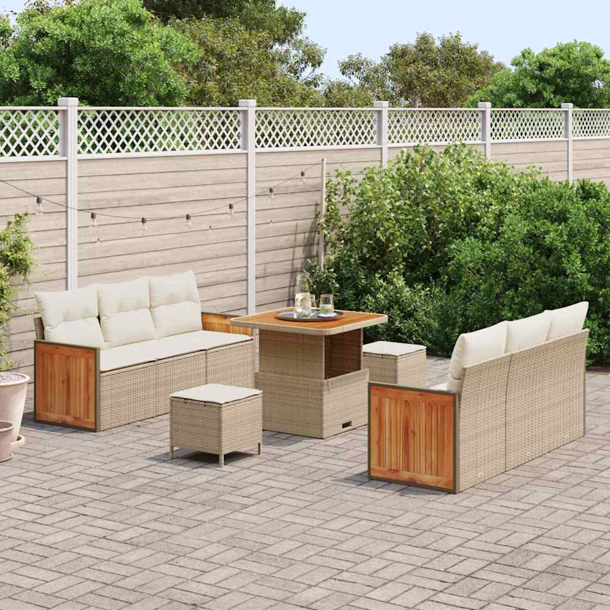 Garten-Terrassenset mit beigefarbenen Kissen und Korbmöbeln. Holztisch und zwei Sofas. Ein Zaun und Grünzeug im Hintergrund.