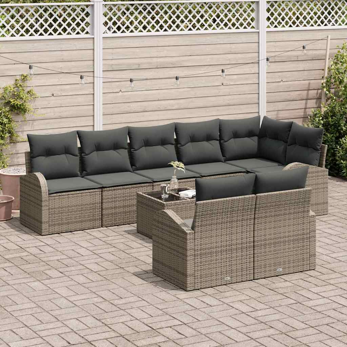 Garten-Terrassenset mit grauen Kissen. Vor dem Sofa steht ein Tisch mit einer Vase. Überkopf hängen Lichterketten.