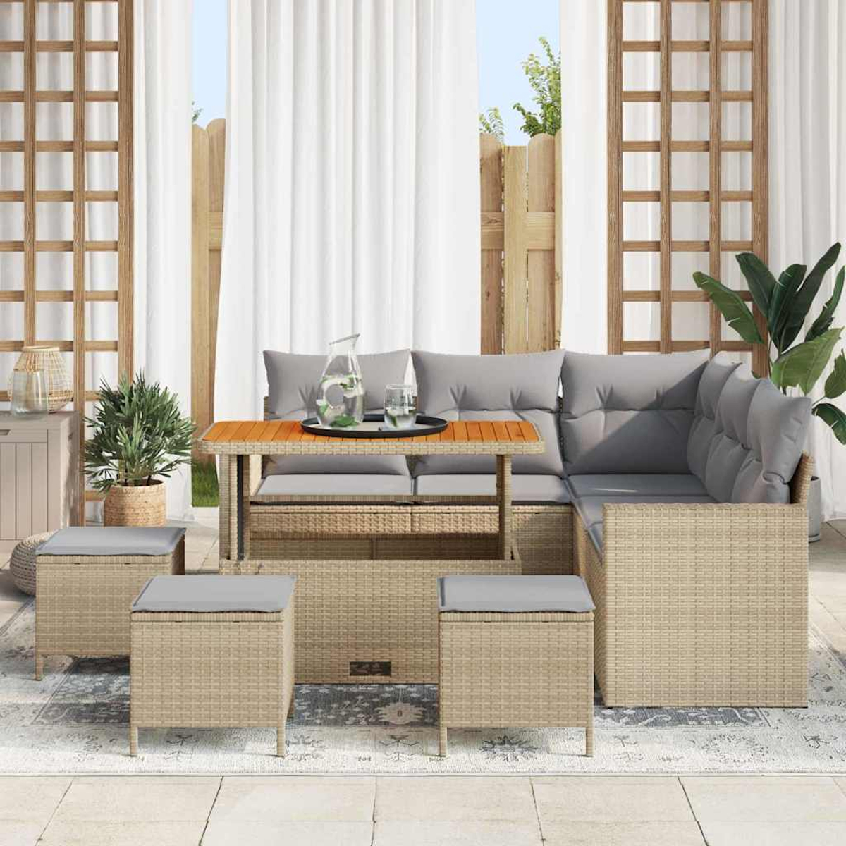 Gartenmöbel-Set mit Tisch, Ecksofa und drei Hockern. Helles, beiges, gewebtes Material mit grauen Kissen.