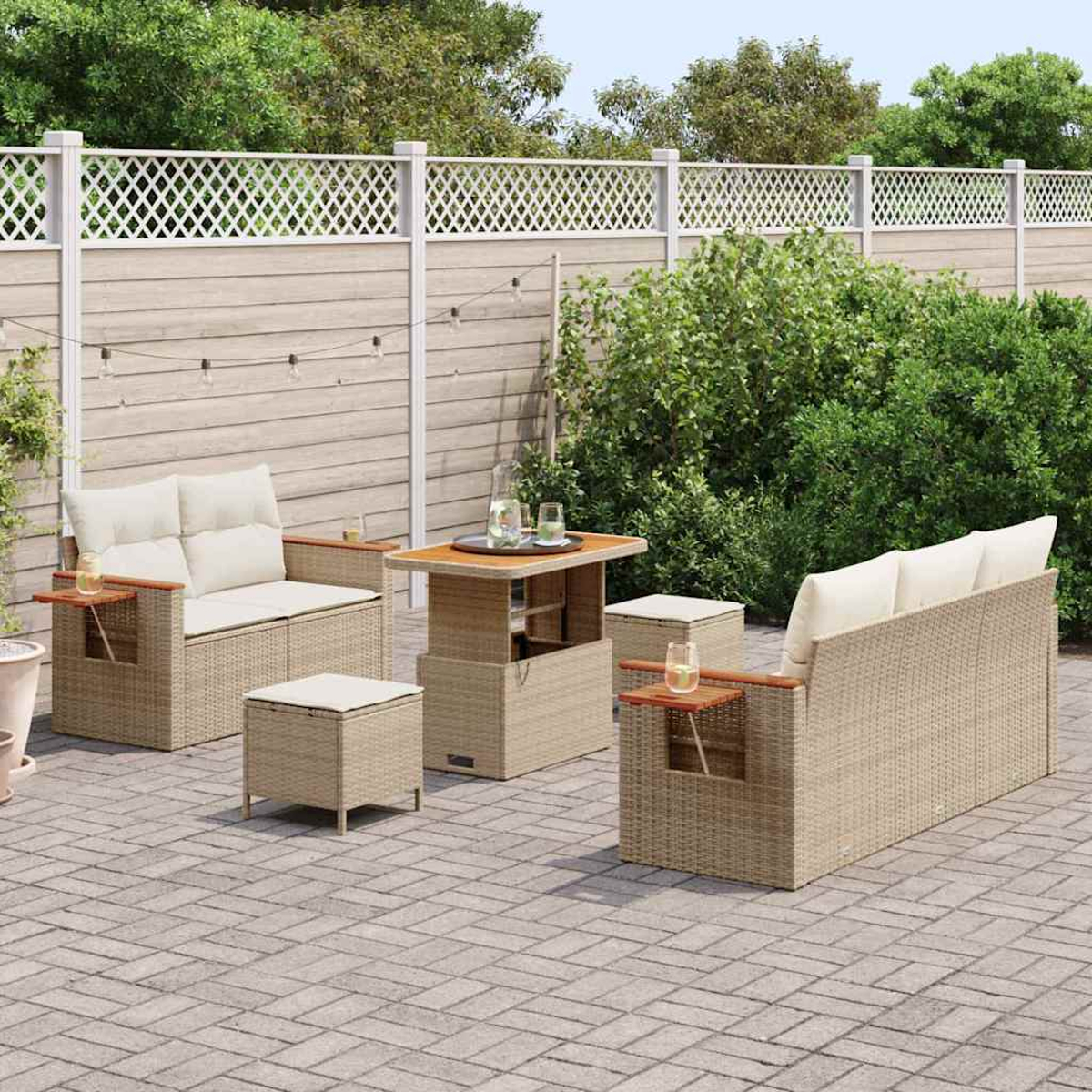 Gartenmöbel-Set: Sofa, Stühle, Tisch und Ottoman. Beige Korbgeflecht mit hellen Kissen, auf einer Ziegelterrasse, mit weißem Zaun.