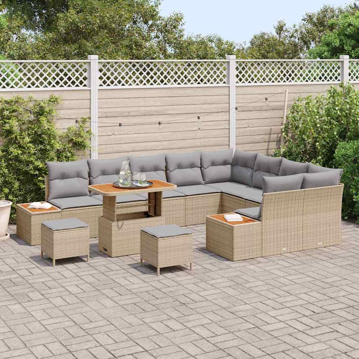 Juego de patio al aire libre con cojines grises, una mesa de madera y otomanas a juego, contra una cerca y vegetación.