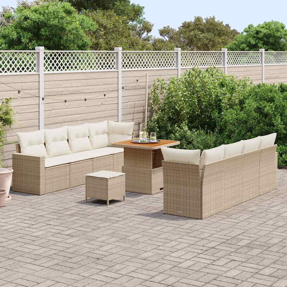 Garten-Sitzgruppe: zwei Sofas, ein Tisch und ein Hocker auf einer gepflasterten Terrasse, mit Zaun und Grün im Hintergrund.