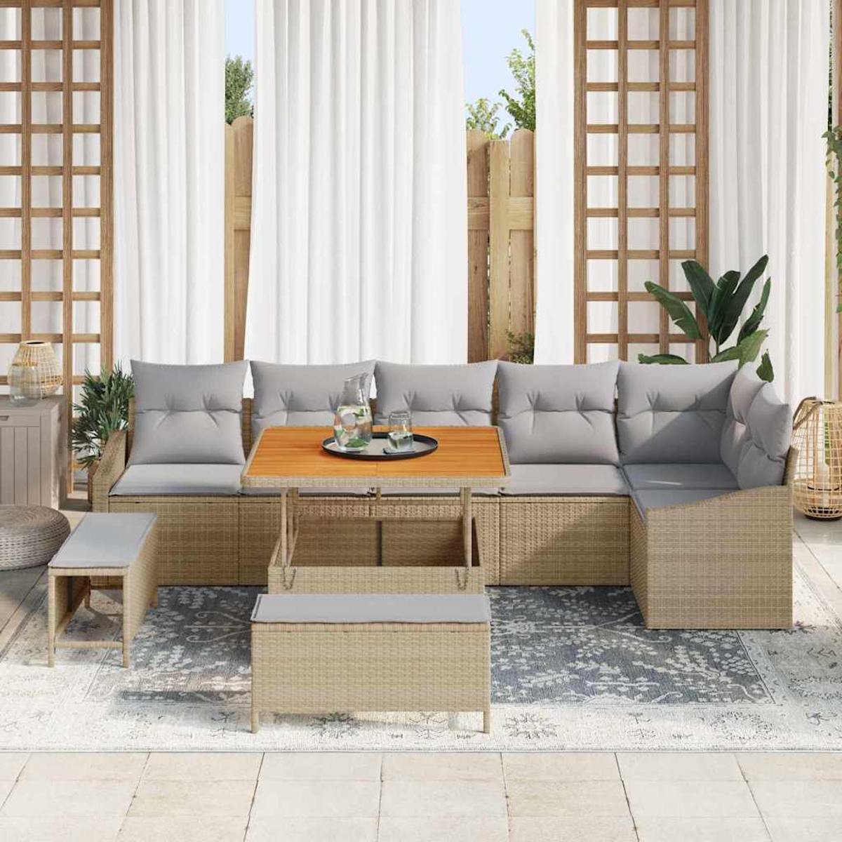 Outdoor-Sitzgruppe. Beiges Korbmöbel-Sofa mit grauen Kissen, Holztisch und Bank. Weiße Vorhänge und Holzgitter im Hintergrund.