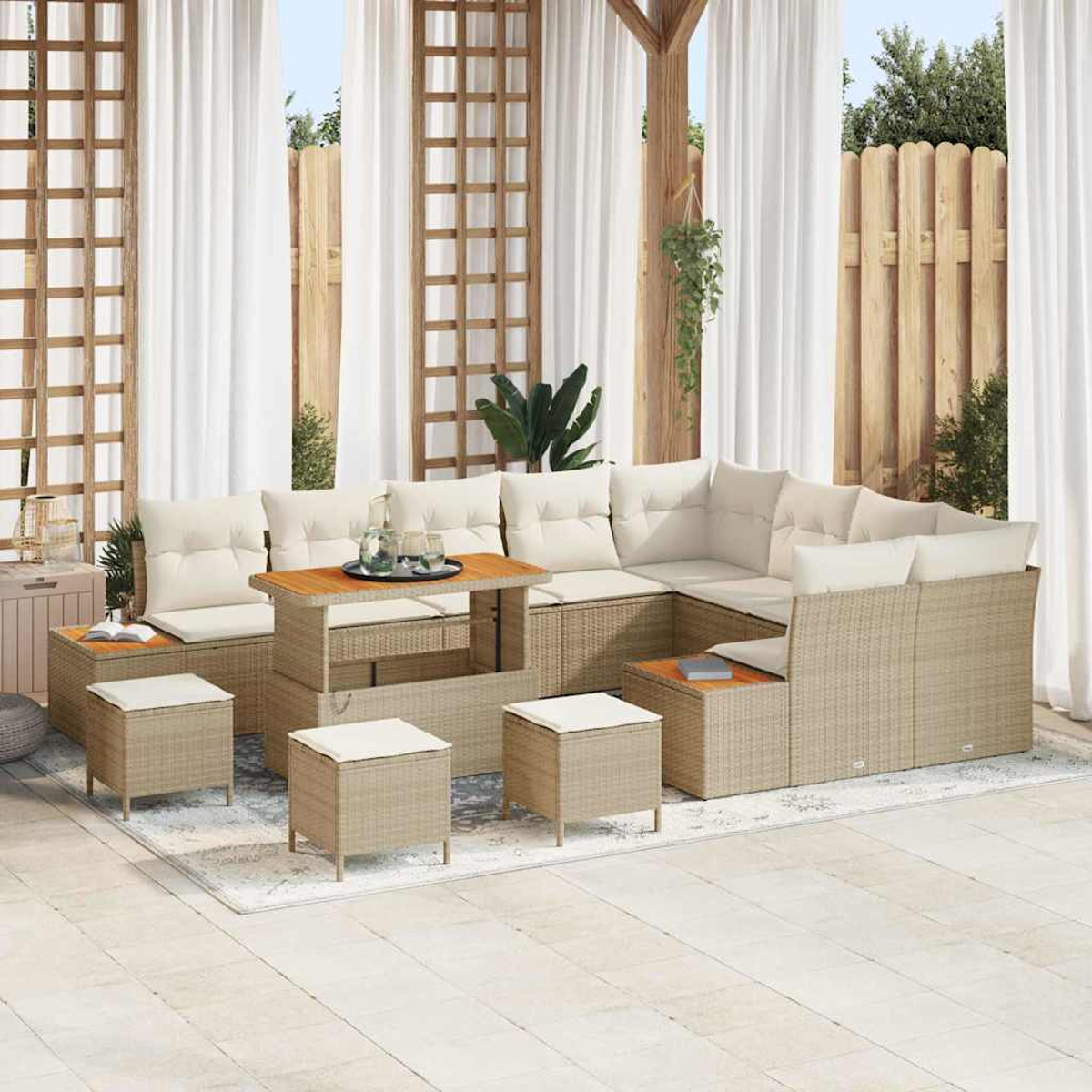 Terrassenset mit beigen Korbmöbeln, weißen Kissen und einem Holztisch. Enthält ein großes Ecksofa, Hocker und Vorhänge.