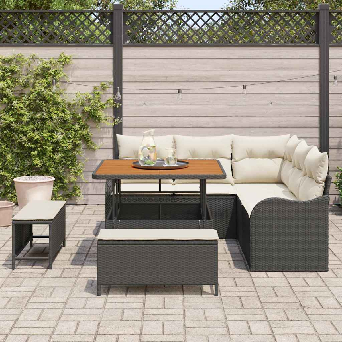 Outdoor-Patio-Set mit einem Korbsessel, einem Holztisch und Bänken auf einer Backsteinterrasse vor einem Holzzaun.