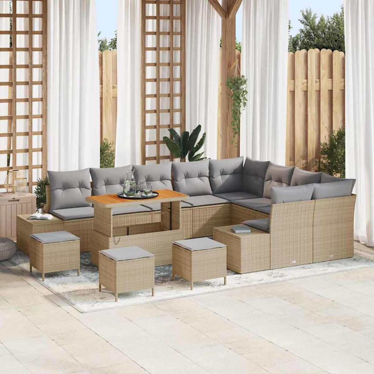 Terrassenmöbel-Set mit Ecksofa, Ottomanen und Couchtisch. Graue Kissen, beiges Korbgeflecht und ein hellfarbiger Teppich.