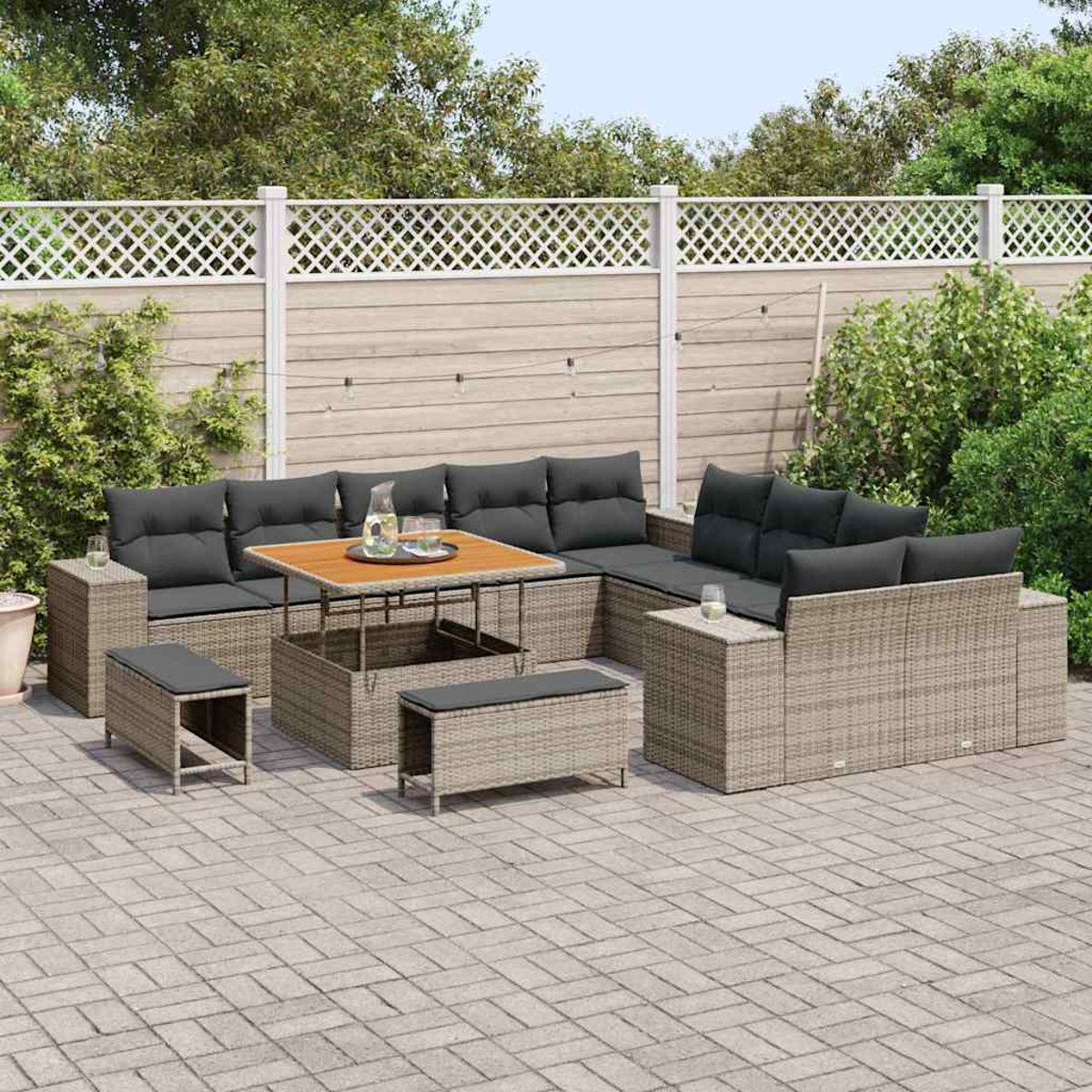 Gartenmöbel-Set aus Korbgeflecht mit grauen Kissen und einem Holztisch. Auf einer Backstein-Terrasse vor einem weißen Zaun und grünen Pflanzen.
