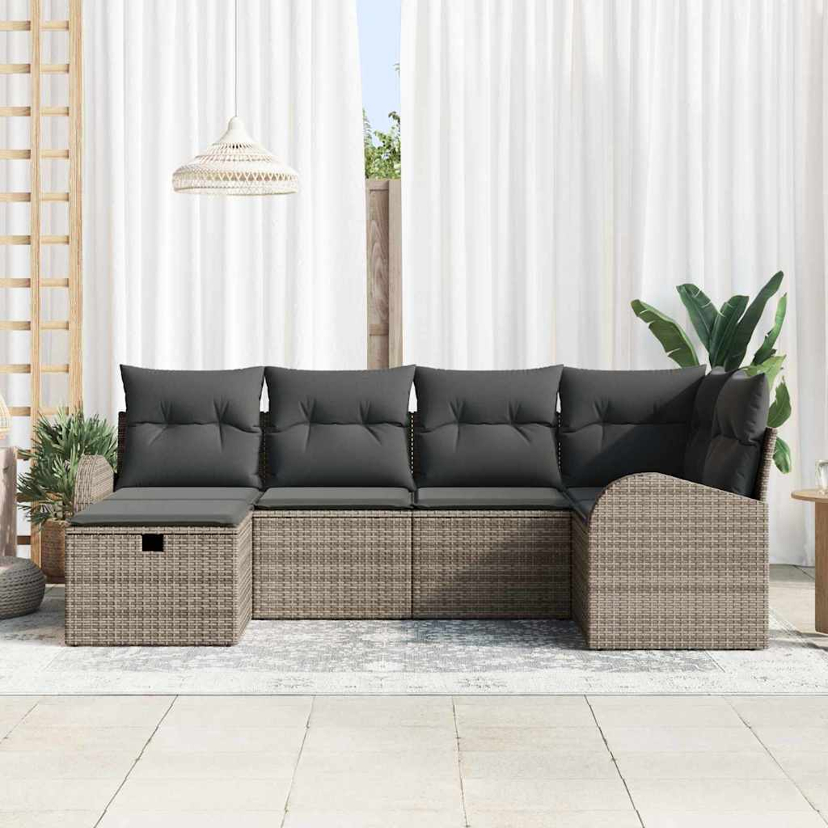 Outdoor-Ecksofa mit grauen Kissen. Hintergrund: weiße Vorhänge, eine Hängelampe und Topfpflanzen. Der Boden ist gefliest.