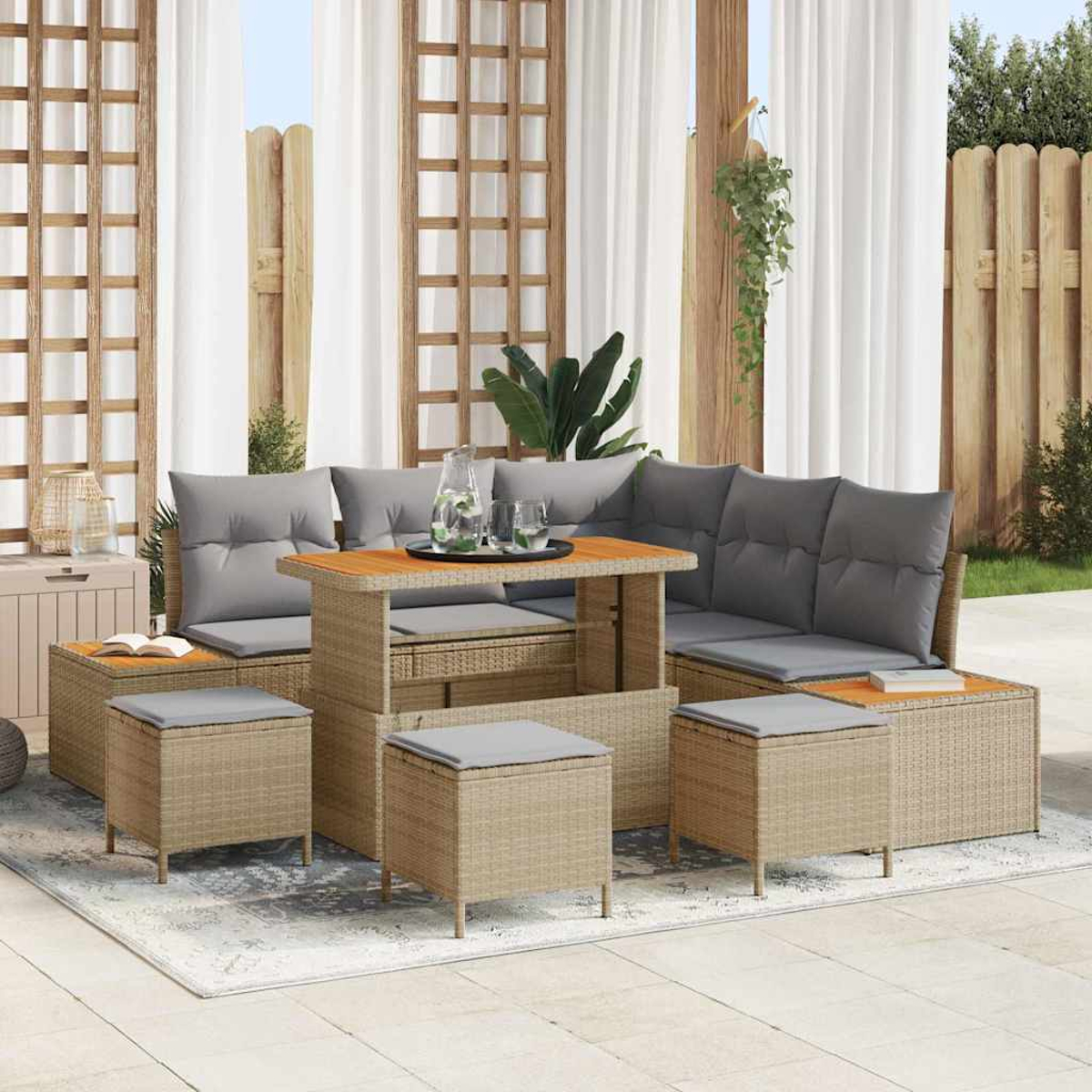 Outdoor-Sitzgruppe mit grauen Kissen und Holztisch, auf einer Terrasse mit Vorhängen und Holzzaun im Hintergrund.