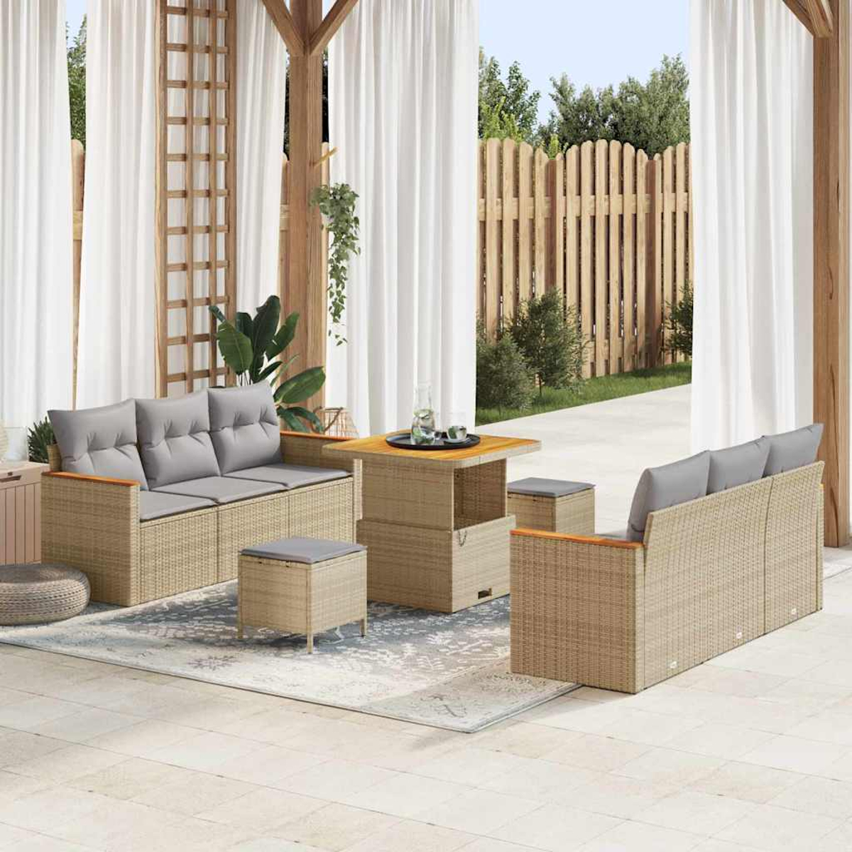 Gartenmöbel-Set. Beige Korbsessel, Tisch und Hocker mit grauen Kissen. Hintergrund mit Vorhängen und Holzzaun.