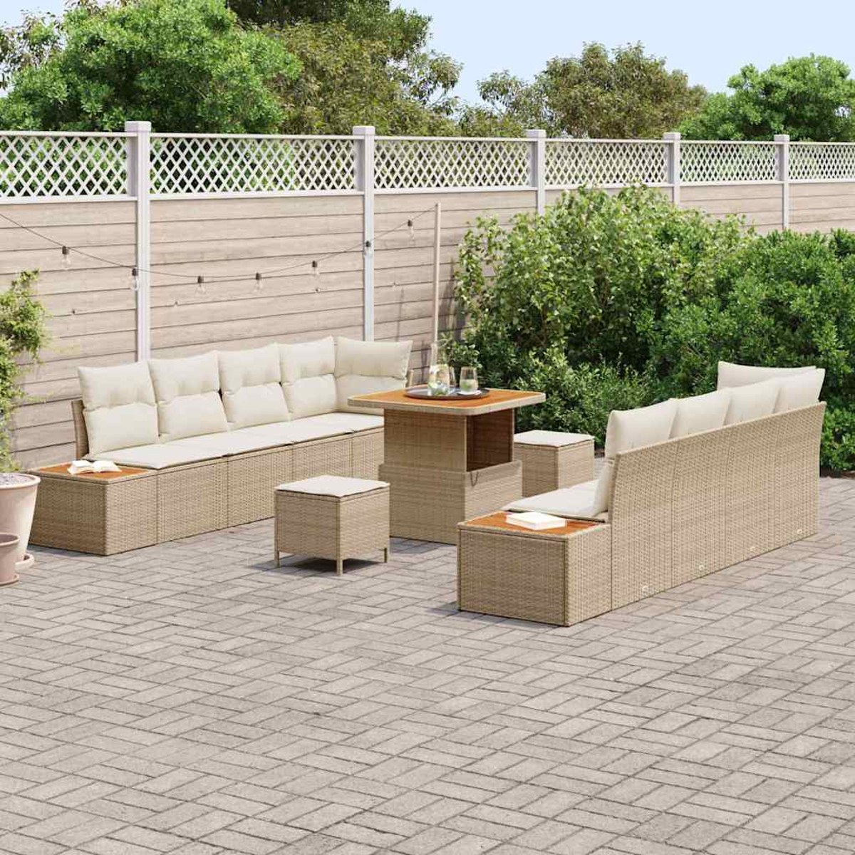 Garten-Terrassenset mit beigen Kissen. Enthält ein Sofa, einen Tisch und Ottomanen auf einer Ziegelterrasse, umgeben von Grün und einem Zaun.