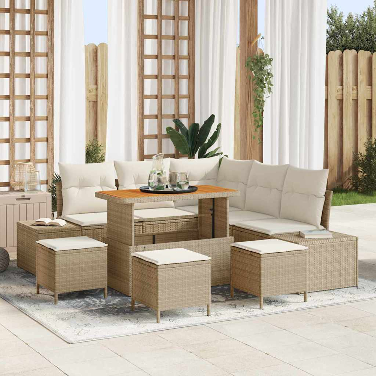 Set da patio esterno con cuscini beige, un tavolo in legno e pouf abbinati. Tende bianche trasparenti sullo sfondo.