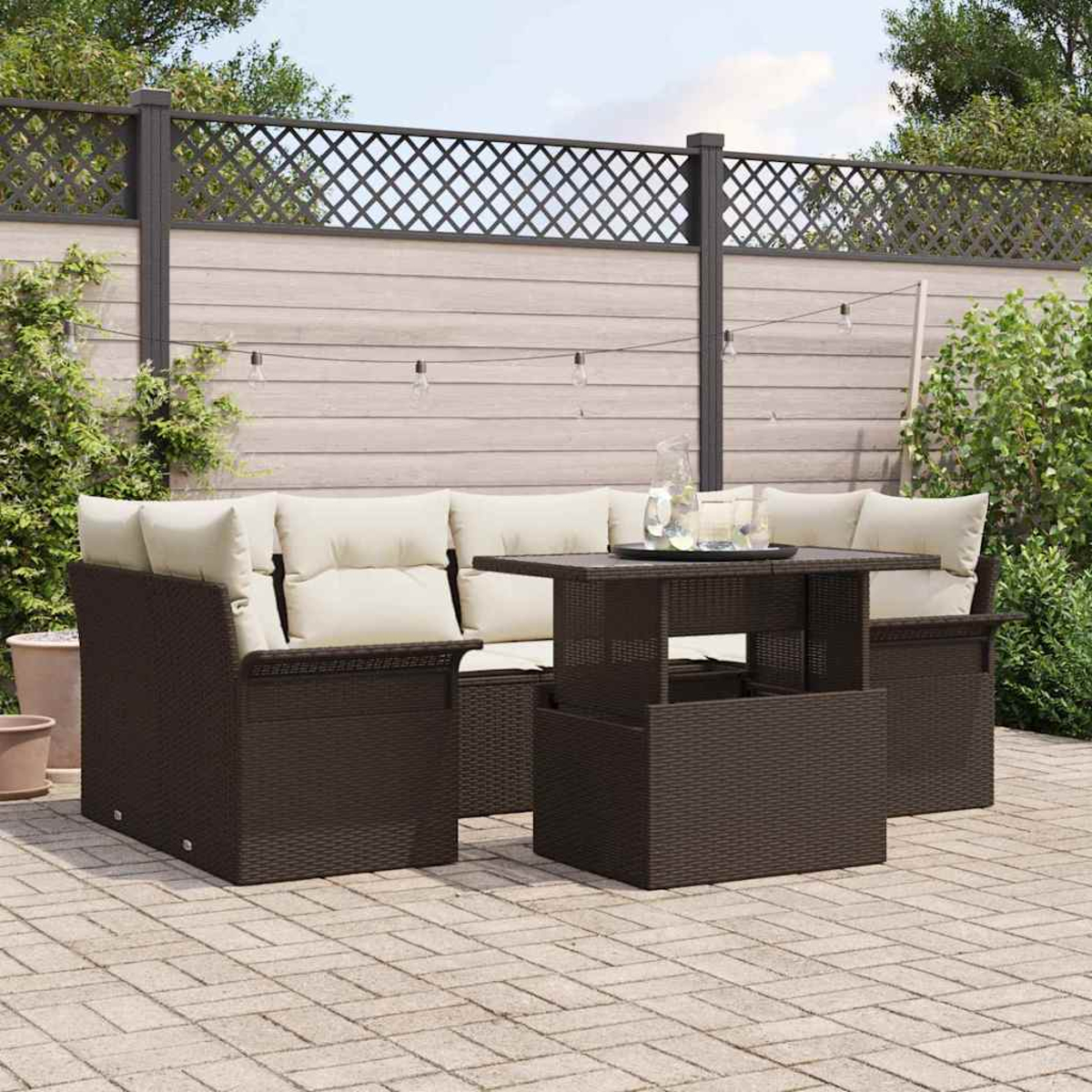 Garten-Terrassenset mit braunen Korbmöbeln und cremefarbenen Kissen. Inklusive Tisch mit Glaskaraffe und Gläsern. Im Hintergrund ein Zaun.