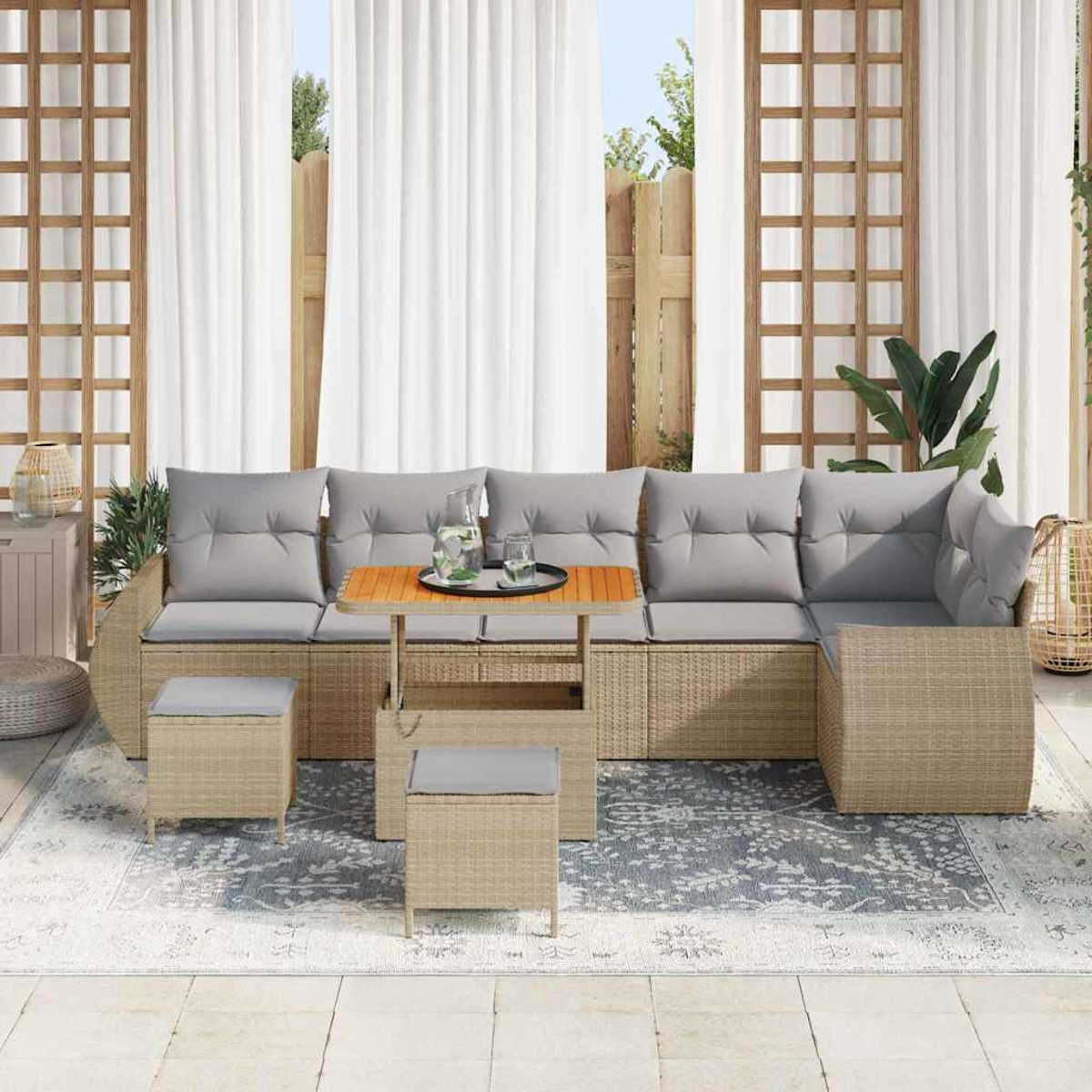 Ein Outdoor-Terrassenset mit Sofa, Ottomanen und einem Tisch. Das Set steht auf einem gemusterten Teppich, im Hintergrund weiße Vorhänge.