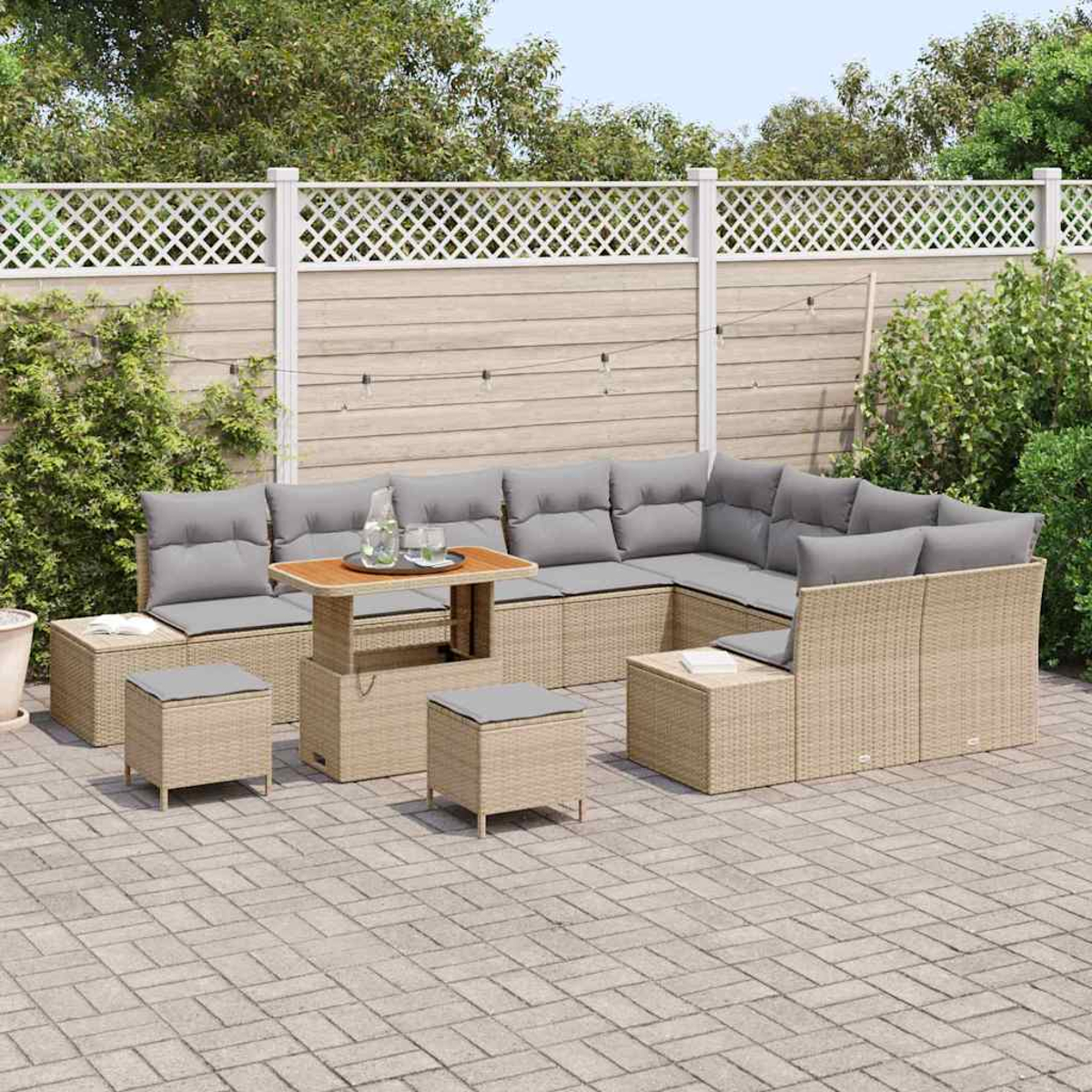 Outdoor-Terrassenset mit großem Ecksofa, Tisch und Hockern. Graue Kissen auf beigen Korbmöbeln. Ein weißer Zaun im Hintergrund.