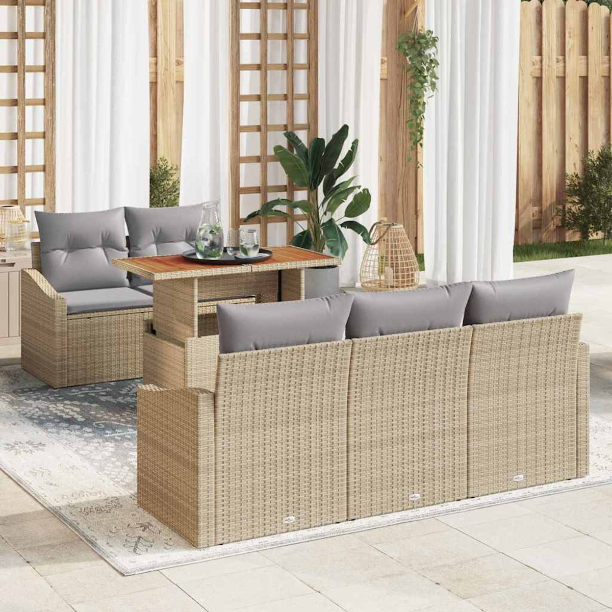 Gartenmöbel-Set aus Korbgeflecht mit grauen Kissen. Enthält Sofa, Stühle und Tisch. Im Hintergrund Pflanzen und ein Holzzaun.