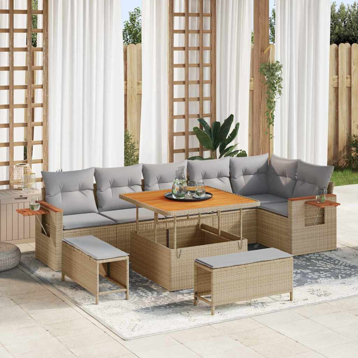 Divano angolare in vimini da esterno con cuscini grigi e tavolo in legno. Include due pouf, un tappeto e uno sfondo a traliccio in legno.