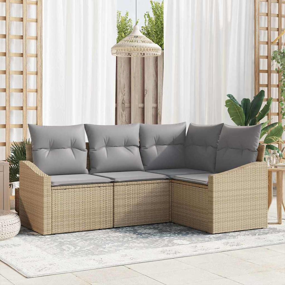Ein beiges Korbsesselsofa mit grauen Kissen steht auf einem Teppich, in der Nähe eines Fensters mit weißen Vorhängen und einer Hängelampe.