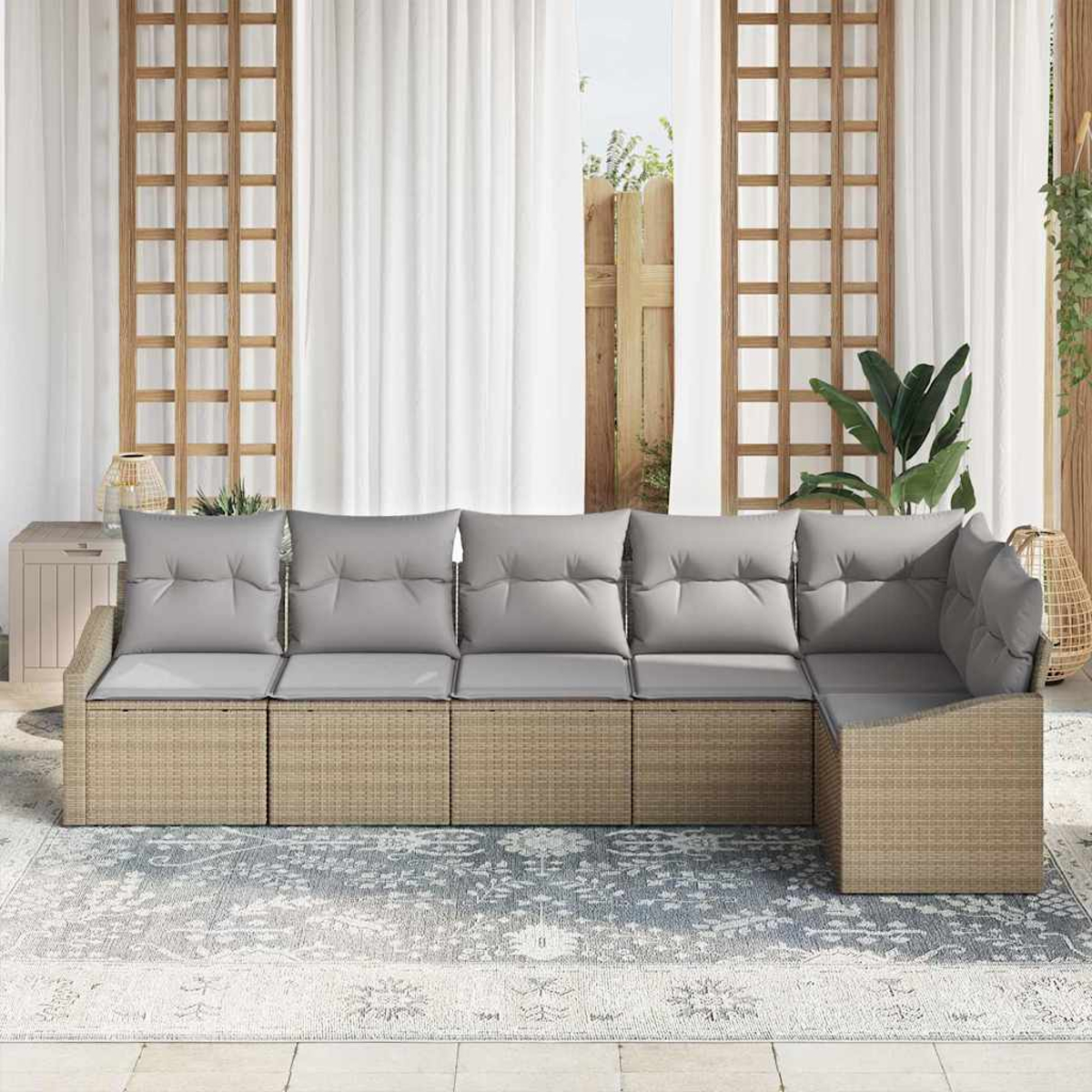 Ein Ecksofa im Freien mit grauen Kissen steht auf einem gemusterten Teppich. Vorhänge und Holzgitter sind hinter dem Sofa.