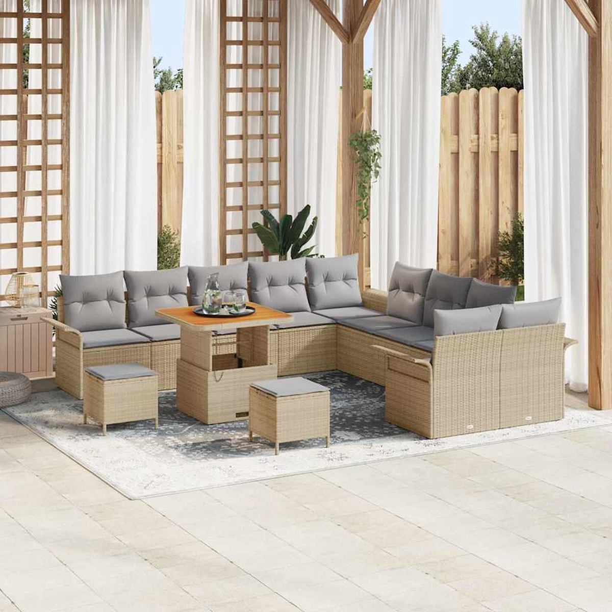 Terrassenmöbel-Set im Freien mit beigen Korbmöbeln und grauen Kissen. Beinhaltet einen Tisch, ein Ecksofa und Hocker auf einem gemusterten Teppich.