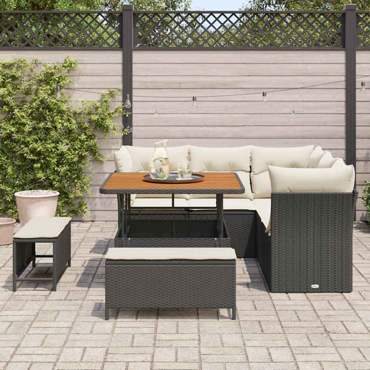 Outdoor-Ecksofa-Set mit Kissen, Tisch und Bänken auf einer Terrasse. Der Hintergrund umfasst einen Zaun und Topfpflanzen.
