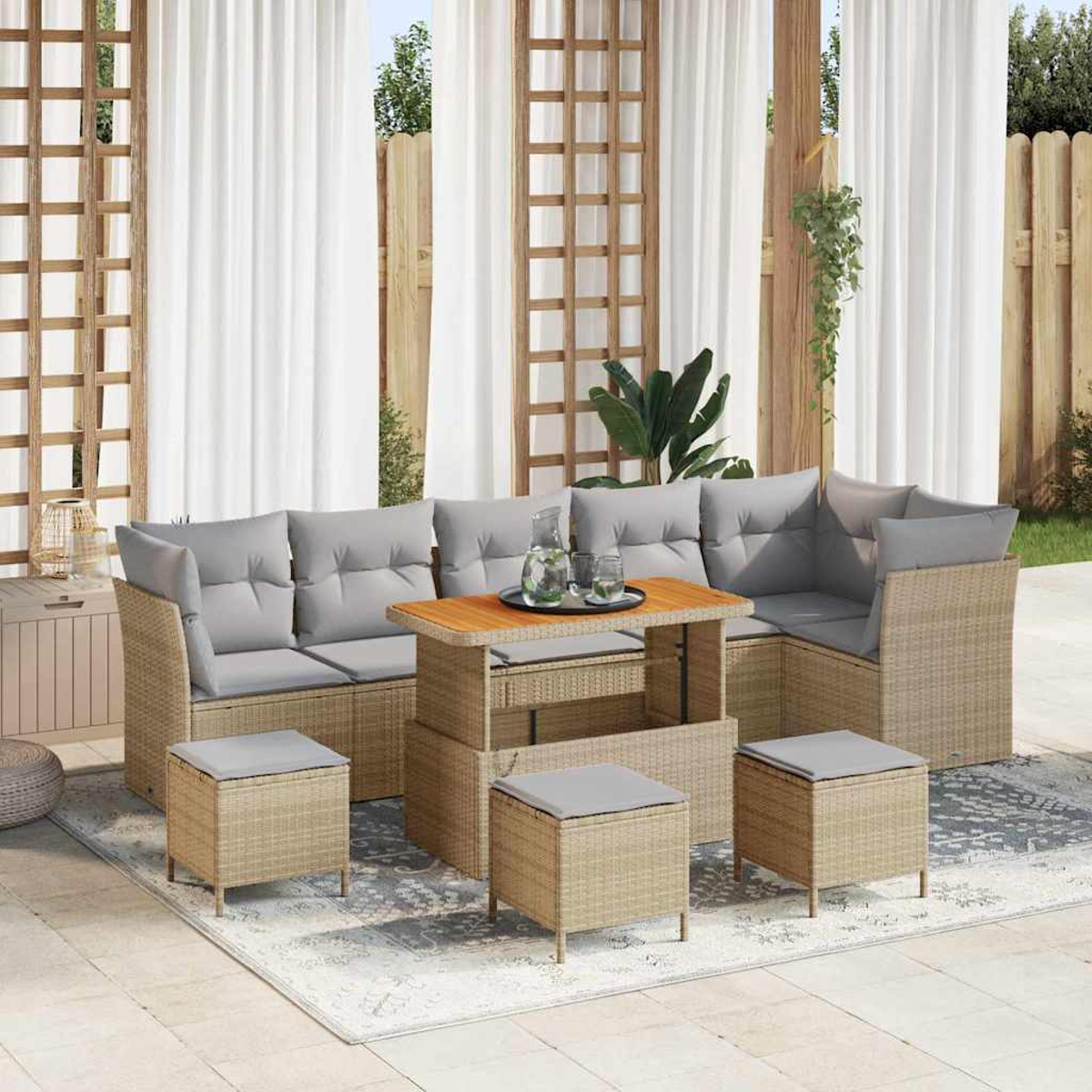 Garten-Sitzgruppe mit grauen Kissen und einem Holztisch. Beinhaltet ein Ecksofa, Hocker und einen Couchtisch auf einem gemusterten Teppich.