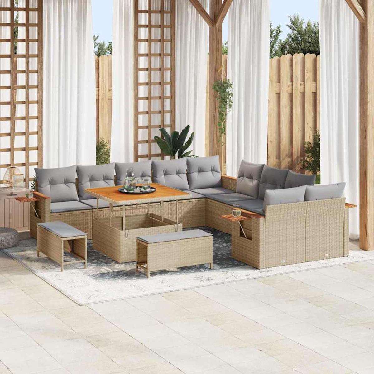 Set da patio esterno con ampio divano angolare, tavolino e panche. Cuscini grigi, dettagli in legno e tende bianche.