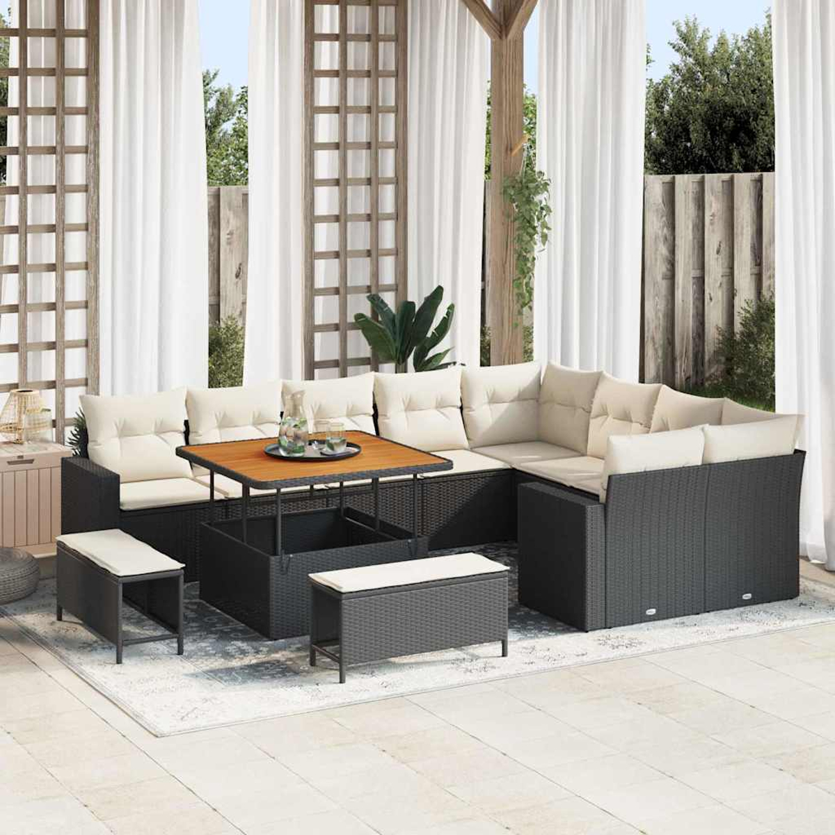 Outdoor-Ecksofa mit beigen Kissen, Holztisch und Bänken. Auf einer Terrasse mit weißen Vorhängen und einem Holzgitter.