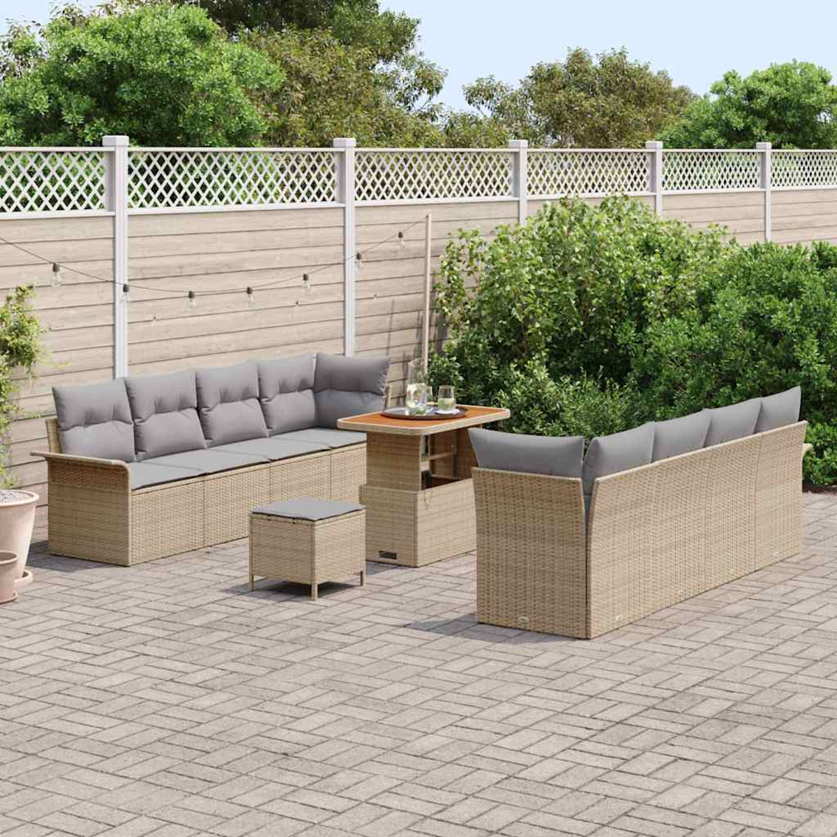 Garten-Terrassenset mit beigen Korbs Sofas, grauen Kissen und einem Tisch mit Hubfunktion auf einer Backsteinterrasse.
