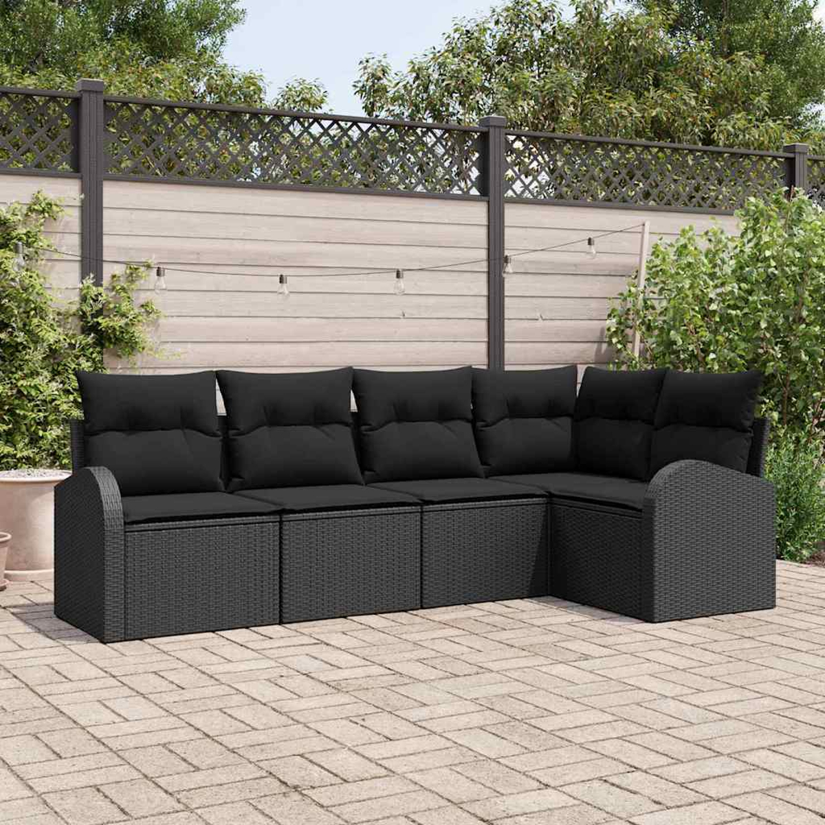 Outdoor-Ecksofa mit schwarzen Kissen auf einer Backstein-Terrasse. Im Hintergrund ein Holzzaun mit Pflanzen und Lichterketten.
