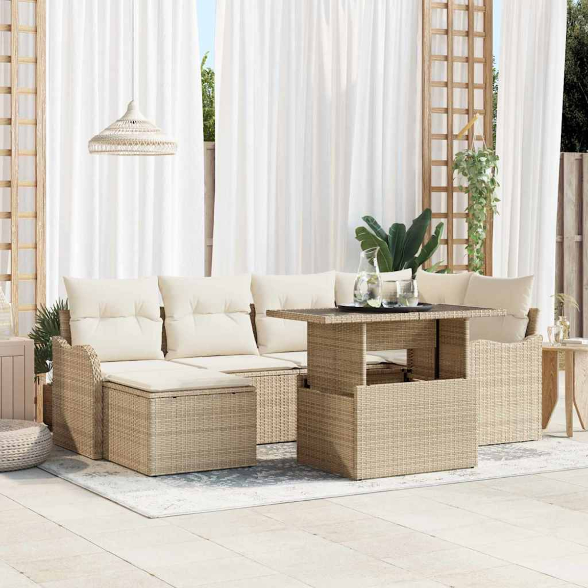 Terrassengarnitur mit Korbmöbeln, cremefarbenen Kissen, Couchtisch, weißen Vorhängen und Hängeleuchte.