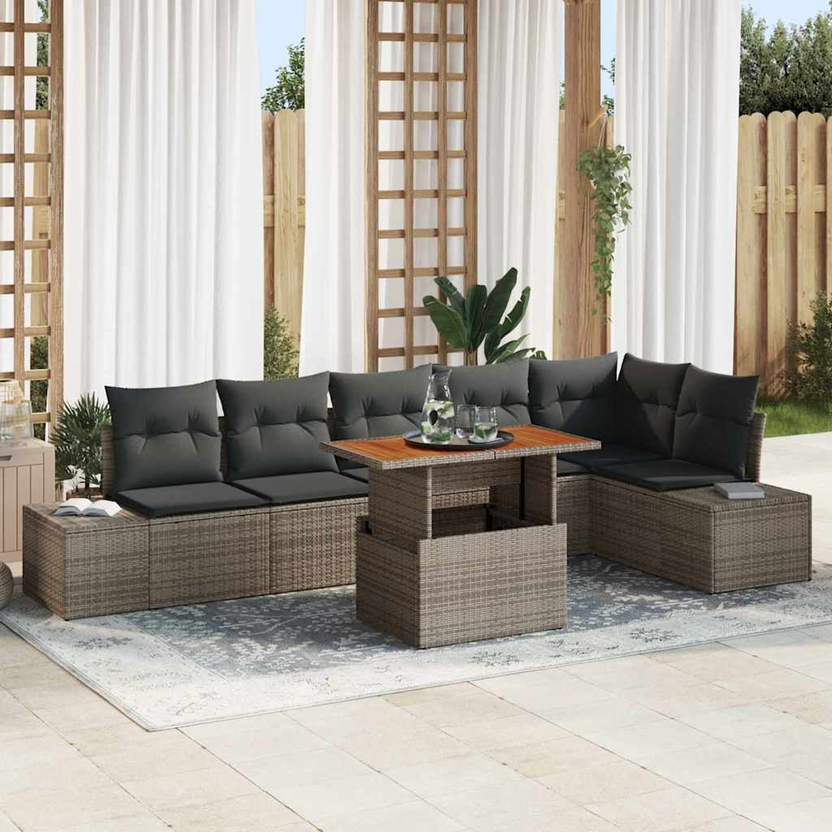 Outdoor-Sitzgruppe mit grauen Kissen und einem Holztisch. Weiße Vorhänge und ein Holzzaun sind im Hintergrund.